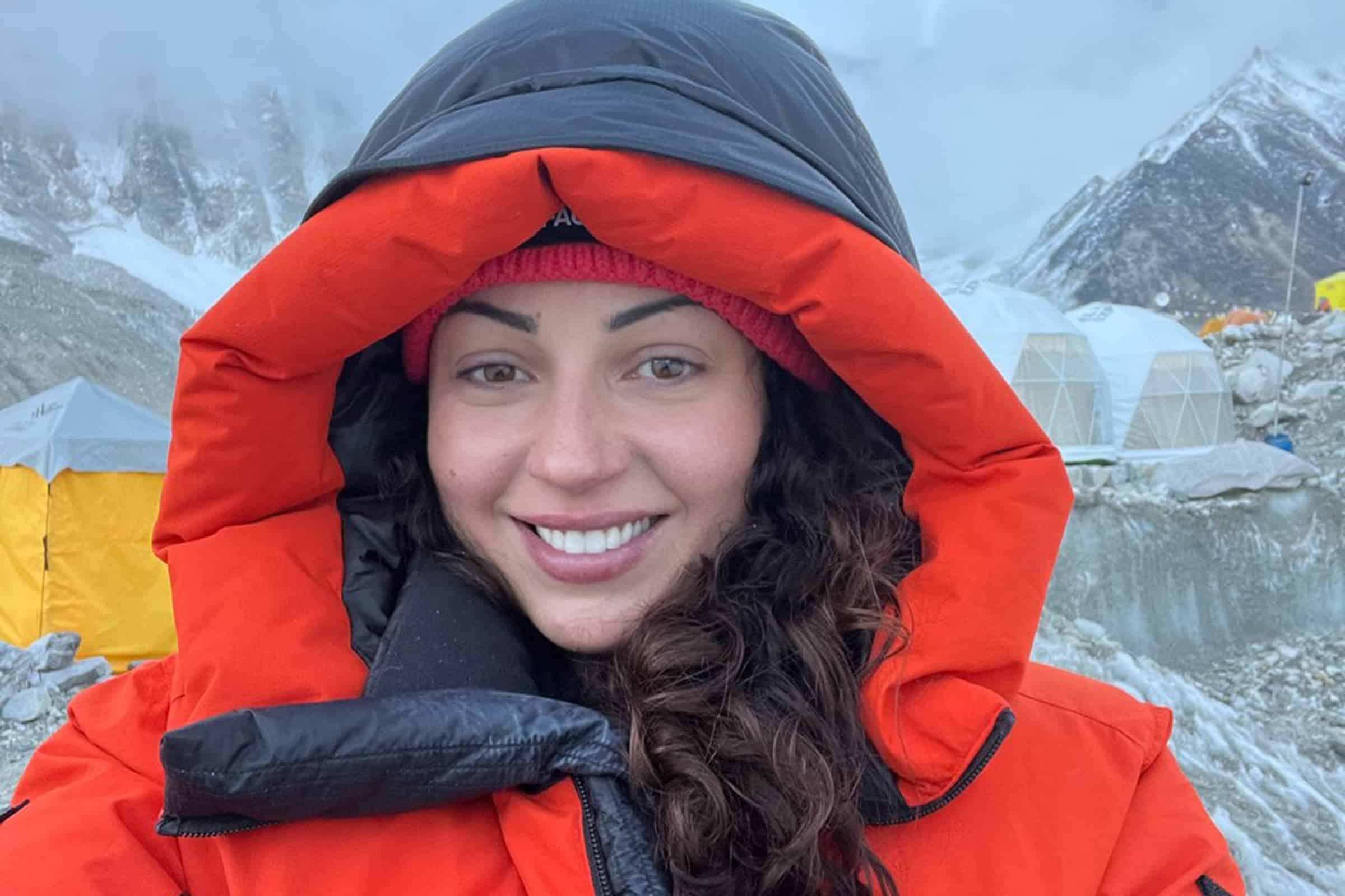 Жінка у великій куртці посміхається в камеру