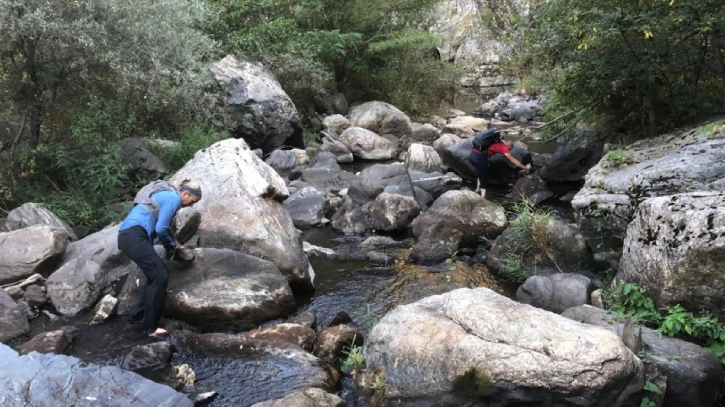 двоє людей перетинають річку